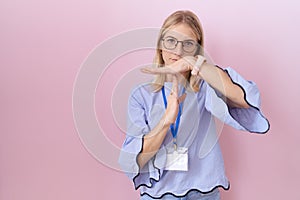 Young caucasian business woman wearing id card doing time out gesture with hands, frustrated and serious face