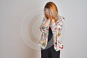 Young caucasian business woman wearing spring floral jacket suit over isolated background with sad expression covering face with