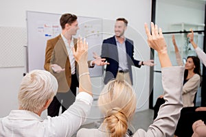 Young caucasian businessman asking opinion and brainstorm of employee while raise hand up for participation together.