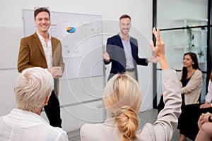 Young caucasian businessman asking opinion and brainstorm of employee while raise hand up for participation together at office.