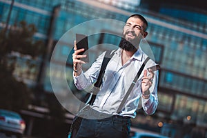 Young caucasian businessman holding a tablet and credit card outdoor