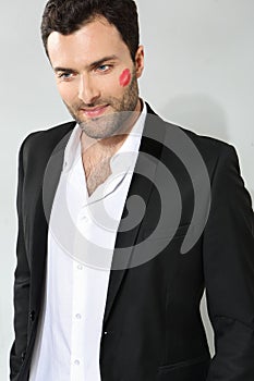 Young caucasian businessman with lipstick kiss mark