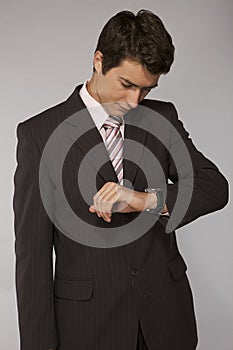 Young caucasian businessman looking on his watch