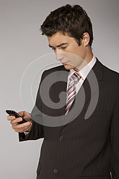 Young caucasian businessman playing with phone