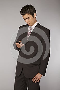 Young caucasian businessman playing with phone