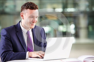 Young Caucasian businessman using laptop computer at work