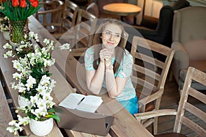 Young caucasian businesswoman in cafe sitting at the table with thoughtful stare.