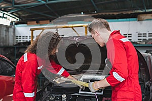 Young Caucasian car mechanic with a checklist, Mechanics in uniform are working in auto service, Technician checking modern car at