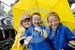 Young caucasian children playing in the rain