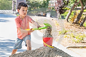 Young Caucasian and Chinese Boy Playing with Shovel and Bucket