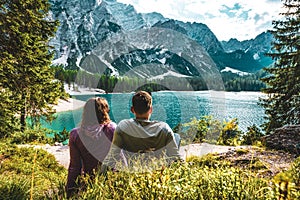 Young caucasian couple enjoying the peaceful view of Baires Lake in the Dolomite mountains, Italy photo