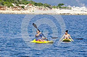 Young caucasian couple kayaking in sea