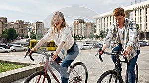 Young caucasian couple riding bicycles in city