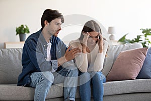 Joven caucásico sentarse sobre el sofá marido calma decepcionado esposa sobre el 