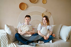 Young caucasian couple, sitting on couch at home, will have fun and quality