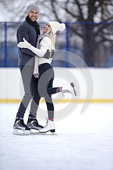 Young Caucasian Couple Skating Together While Standing Embraced On Skatingrink And Having Good Time Outdoors