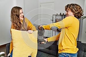 Young caucasian couple smiling confident figthing with pillow at home