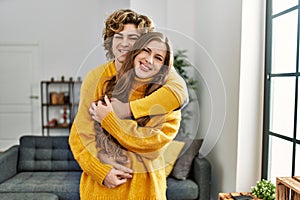 Young caucasian couple smiling confident hugging each other at home