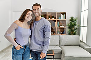 Young caucasian couple smiling happy standing at home