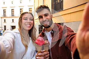 Young Caucasian couple taking a selfie while eating an ice cream.