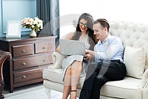 Young caucasian couple using laptop computer at home..shopping online at home. couple planning a trip abroad on their wedding