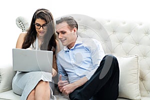 Young caucasian couple using laptop computer at home..shopping online at home. couple planning a trip abroad on their wedding