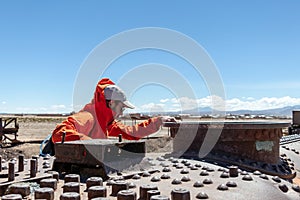 Young caucasian curious man on the abandoned old steam locomotive at steam locomotives cemetery at Uyuni, Bolivia