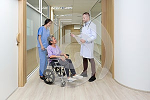 Young caucasian doctor in white gown inform the good news of the test result to asian senior patient in a wheelchair. Healthcare