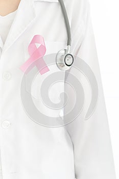 Young caucasian doctor woman with a pink ribbon for the breast cancer awareness pinned in the flap of his white coat