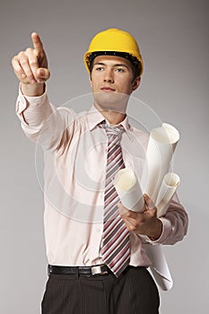 Young caucasian engineer with plans pointing finger away