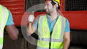 Young caucasian engineer walking checking train diesel engine while high five with partnership in station.