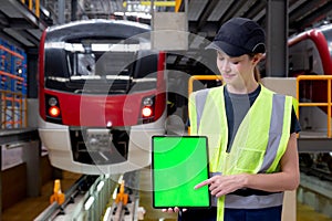 Young caucasian engineer woman or worker holding digital tablet blank and pointing for show and presenting in station.