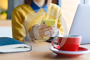 a young Caucasian, European woman in a blue denim shirt and glasses is working on a laptop