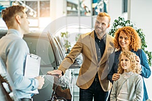 Young caucasian family came to buy new car