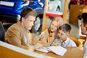 Young caucasian family read documents and talk with consultant before purchase