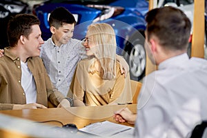 Young caucasian family read documents and talk with consultant before purchase