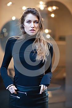 Young caucasian fashionable woman dressed in black clothesposing outdoor, Christmas Eve. Beautiful caucasian girl in Milan, Italy