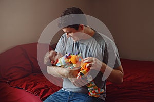 Young Caucasian father playing with newborn baby.