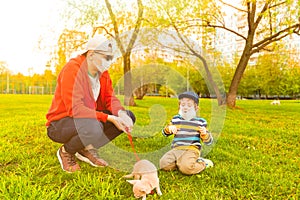 Young caucasian father and son in medical protective masks stay in park at sunny day on grass. Dad and child boy walk