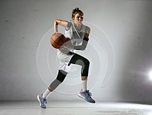 Young caucasian female basketball player against white wall background