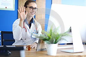 Young caucasian female doctor talking with patient against hospital office background portrait.