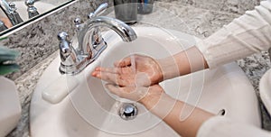Young Caucasian Female Hands Lathering White Bar Hand Soap for Washing and Personal Hygiene, and Then Rinsing Hand Under Sink Wate