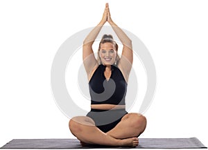 A young caucasian female plus size model sits cross-legged on white background, copy space