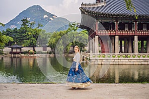 Young caucasian female tourist in hanbok national korean dress at Korean palace. Travel to Korea concept. National