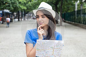 Young caucasian female tourist with map looking around