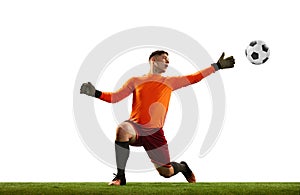 Young caucasian football player, male soccer goalkeeper wearing red football kit isolated over white background. Sport