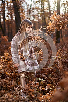 Young caucasian girl, candid autumnal portrait in the forest