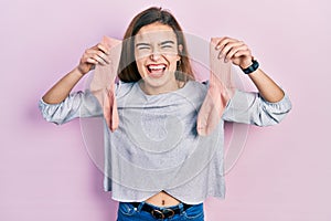 Young caucasian girl holding socks smiling and laughing hard out loud because funny crazy joke