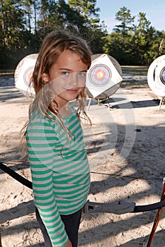 Girl playing archery smiles at the camera