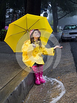 Young caucasian girl playing in the rain